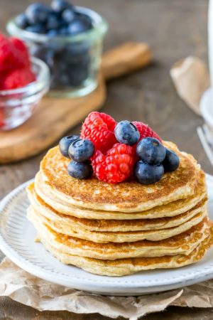 Cottage cheese pancakes next to berries and pitcher
