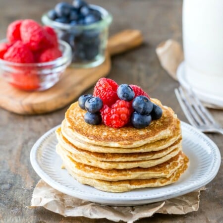 Cottage cheese pancakes next to berries and pitcher