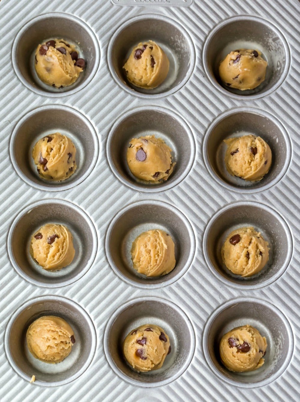 Muffin tin chocolate chip cookie dough in muffin tin