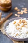 Coconut rice in a blue bowl topped with cashew pieces