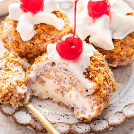 Three scoops of no fry fried ice cream one with a spoonful missing.