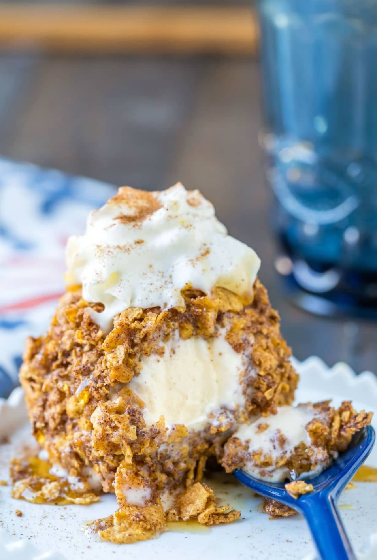 No-Fry Fried Ice Cream on a white dish next to a blue spoon and blue cup