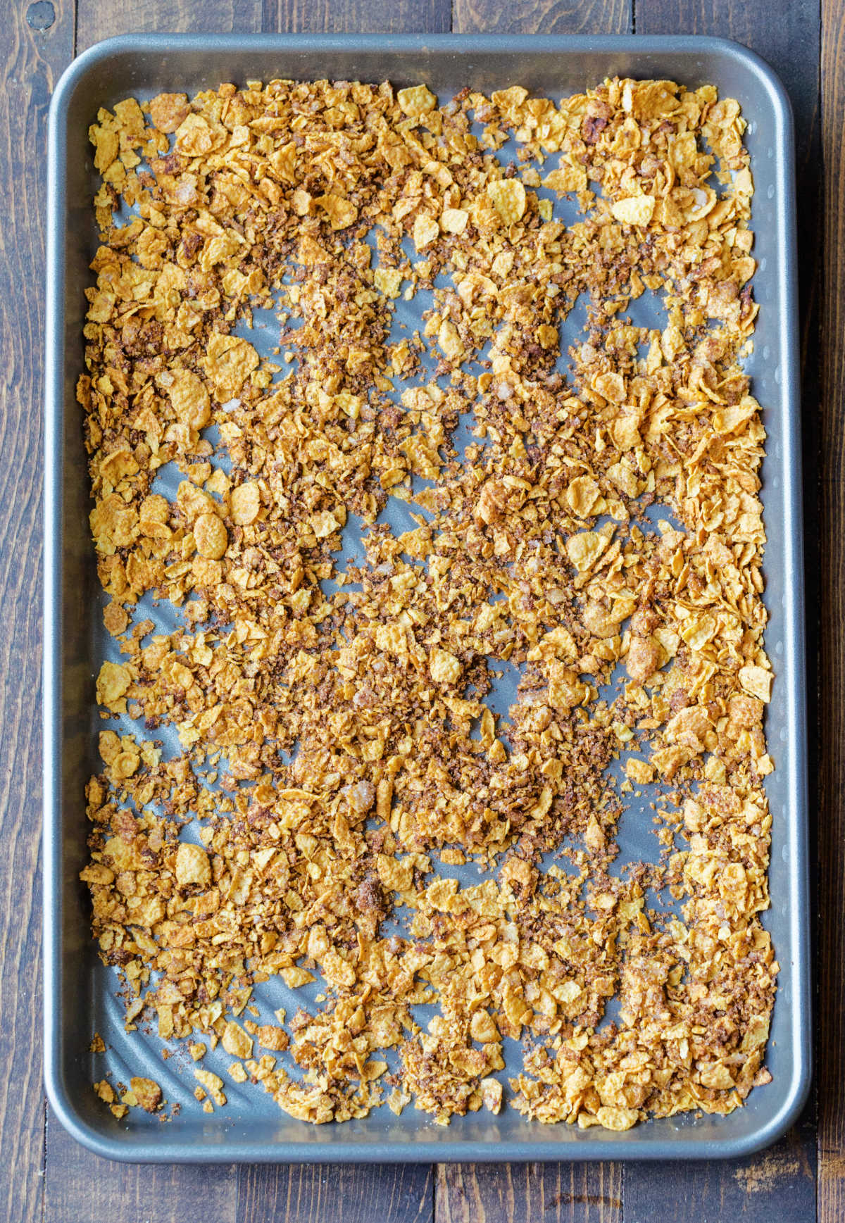 Cornflake coating mixture in a rimmed baking sheet. 