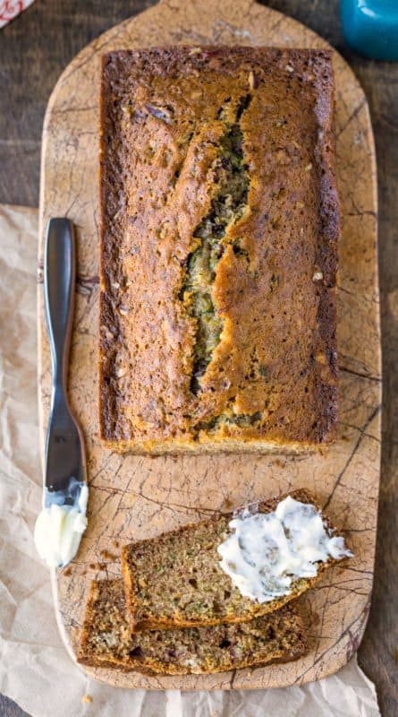 Zucchini bread on a marble cutting board next to a butter knife
