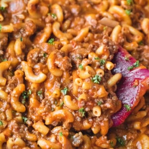 Scoop of homemade hamburger helper topped with chopped parsley