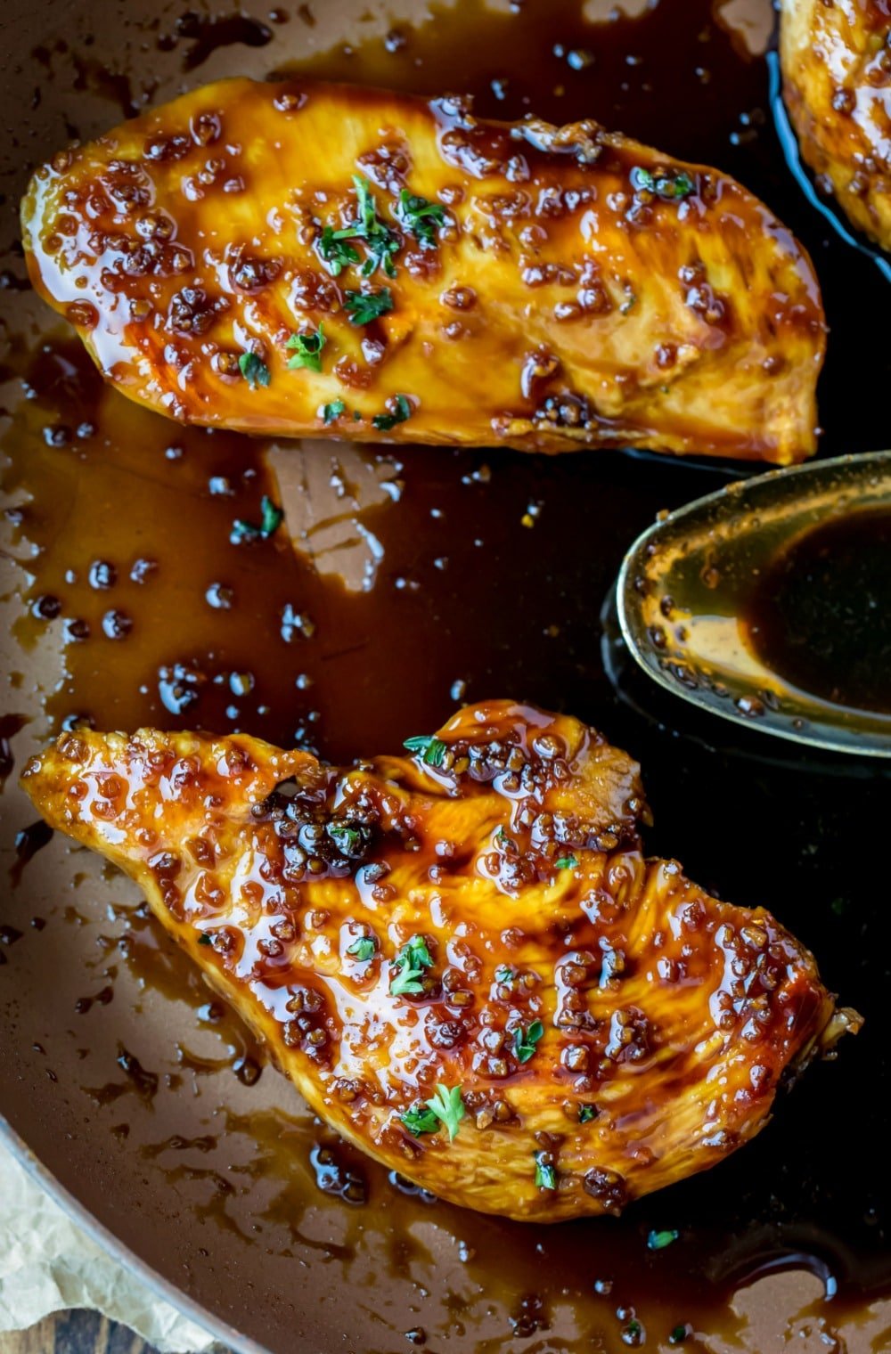 Two pieces of Honey Garlic Chicken in a skillet with sauce