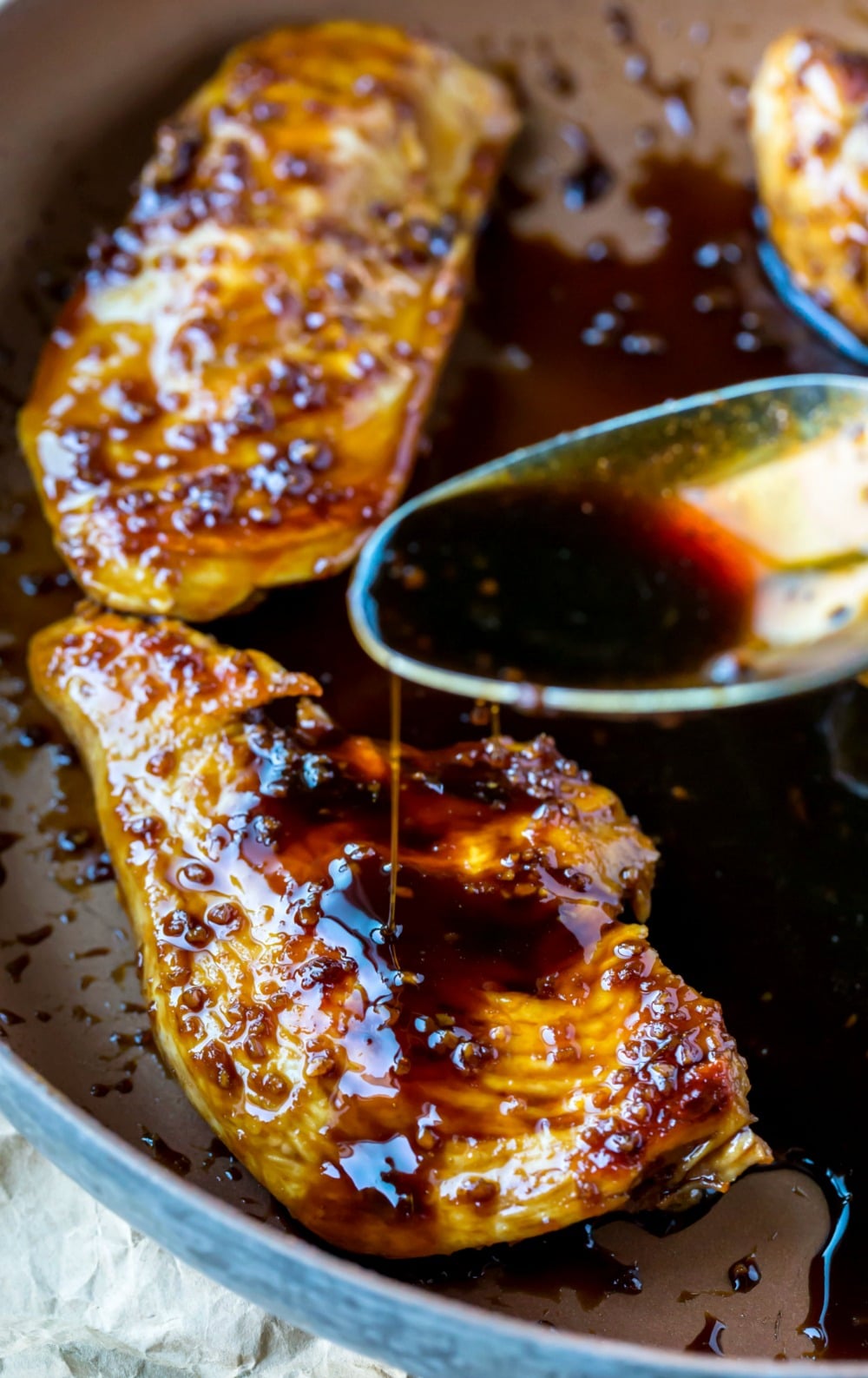 Sauce pouring onto honey garlic chicken