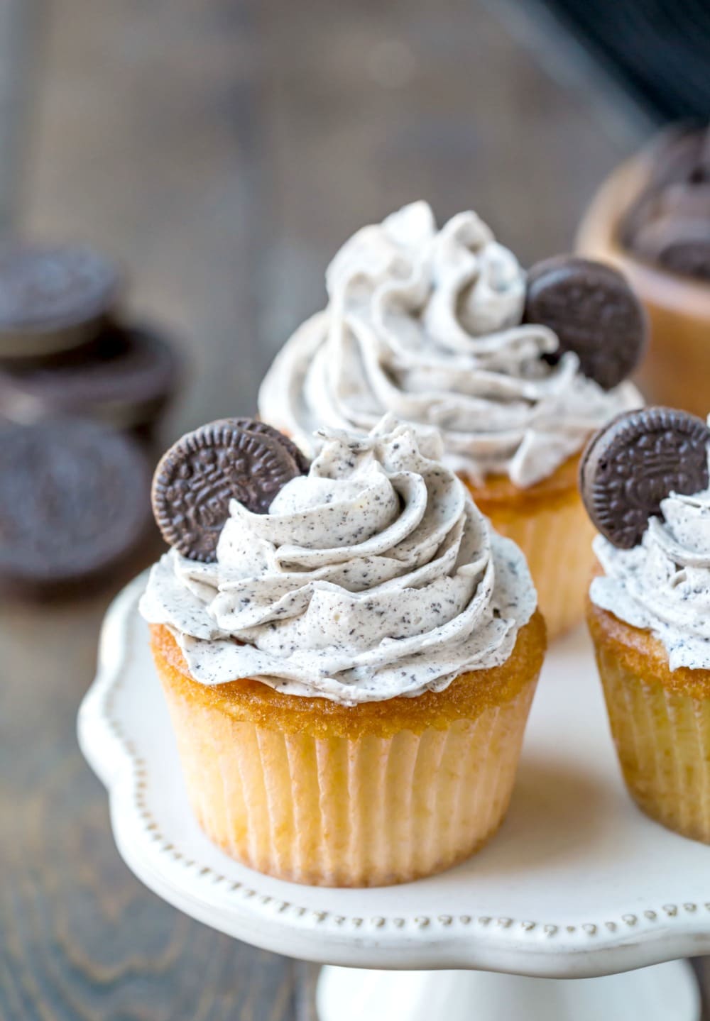 Oreo frosting on a white cupcake on a cake stand