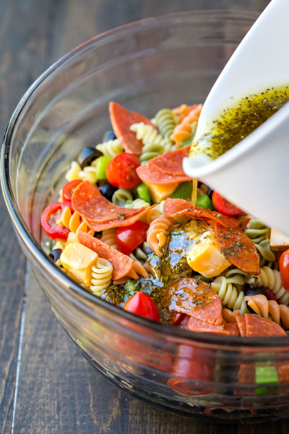 Dressing pouring onto pasta salad