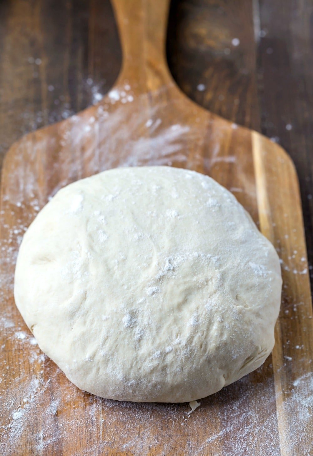 Homemade Pizza Dough Ball of pizza dough on a wooden cutting board