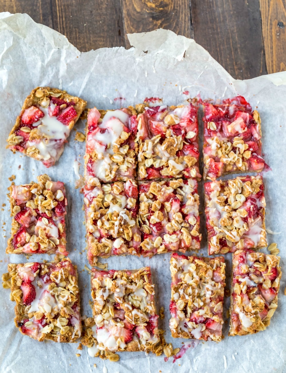 Cut Strawberry Oatmeal Bars on white parchment paper