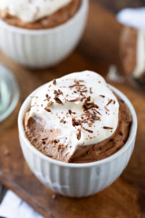 White porcelain cup filled with chocolate mousse and whipped cream