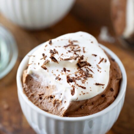 White porcelain cup filled with chocolate mousse and whipped cream