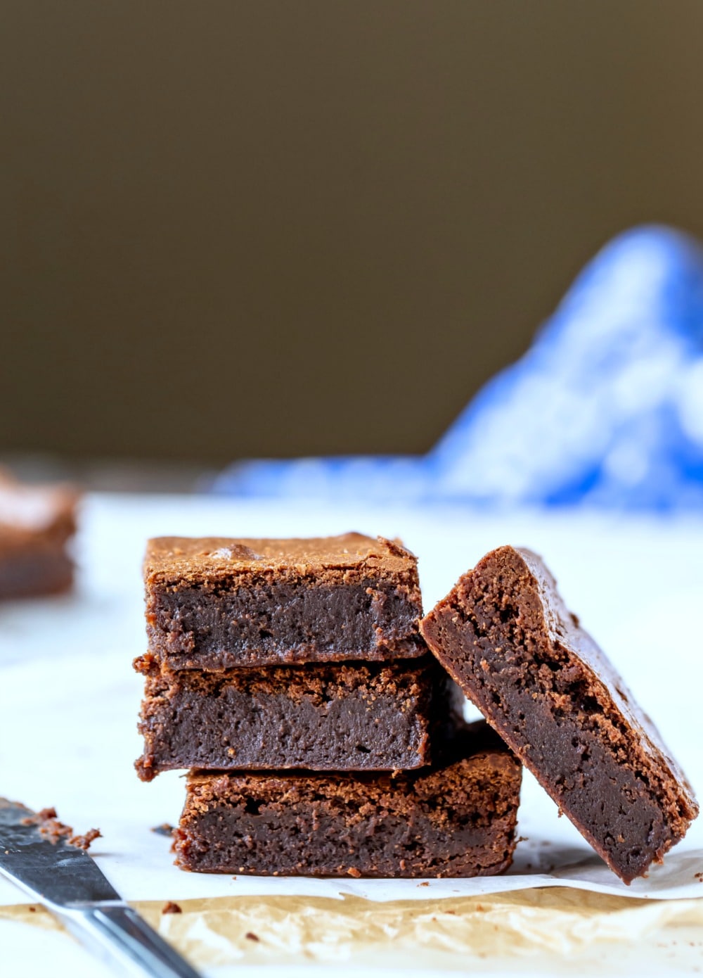 Stack of chewy fudge brownies next to a knife