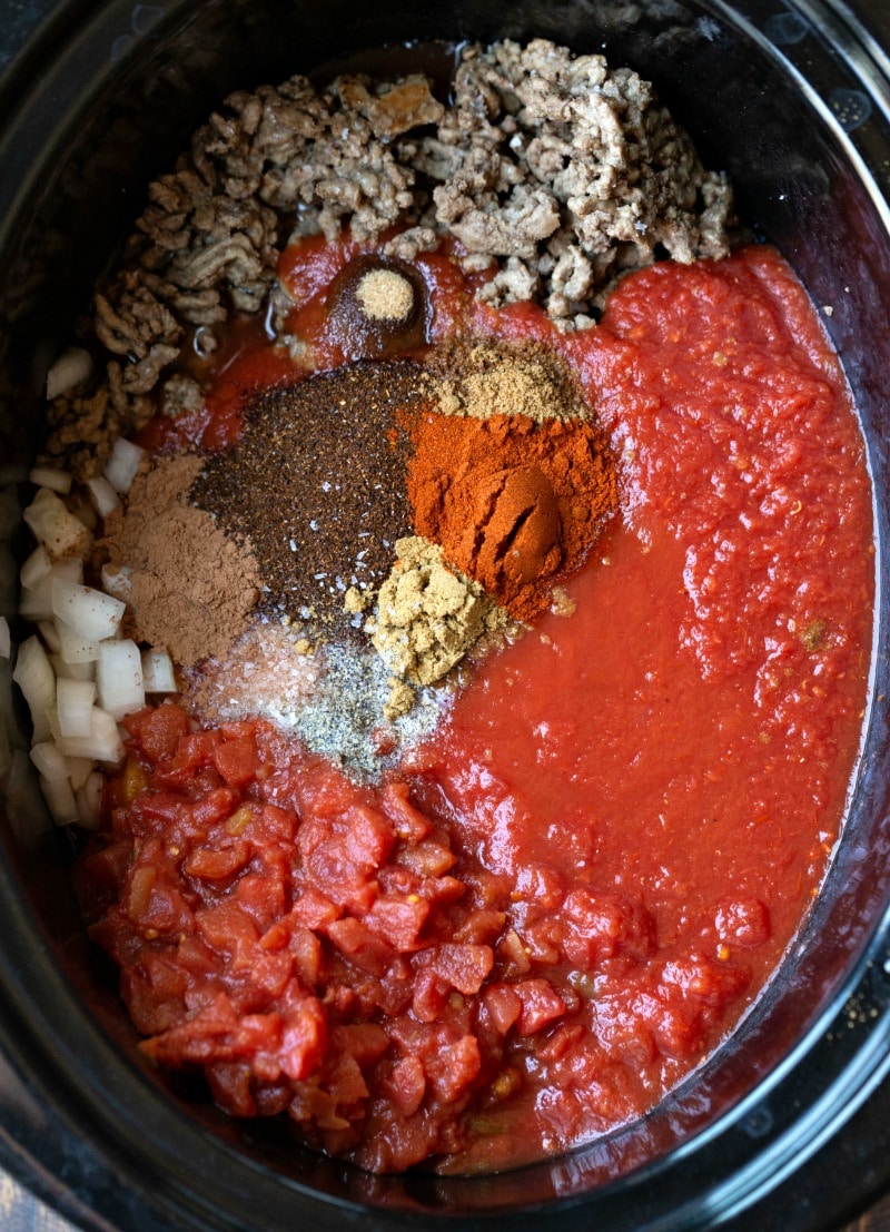 Crockpot chili ingredients in a slow cooker insert