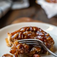 Sticky Bun on a cream plate on a wooden cutting board