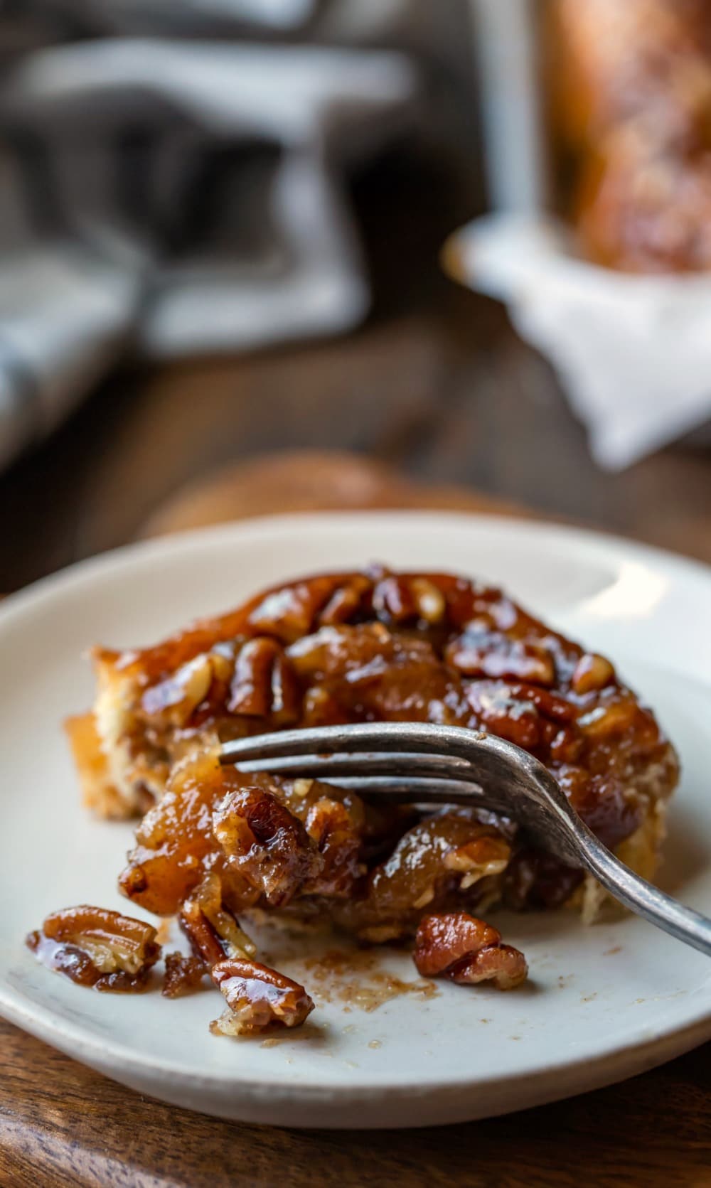 Easy sticky Bun on a cream plate on a wooden cutting board