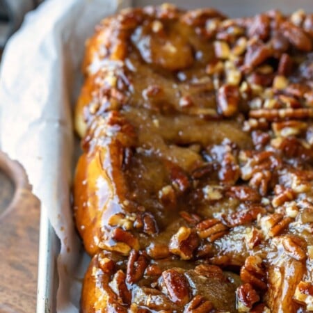 A tray of sticky buns lined with parchment paper.