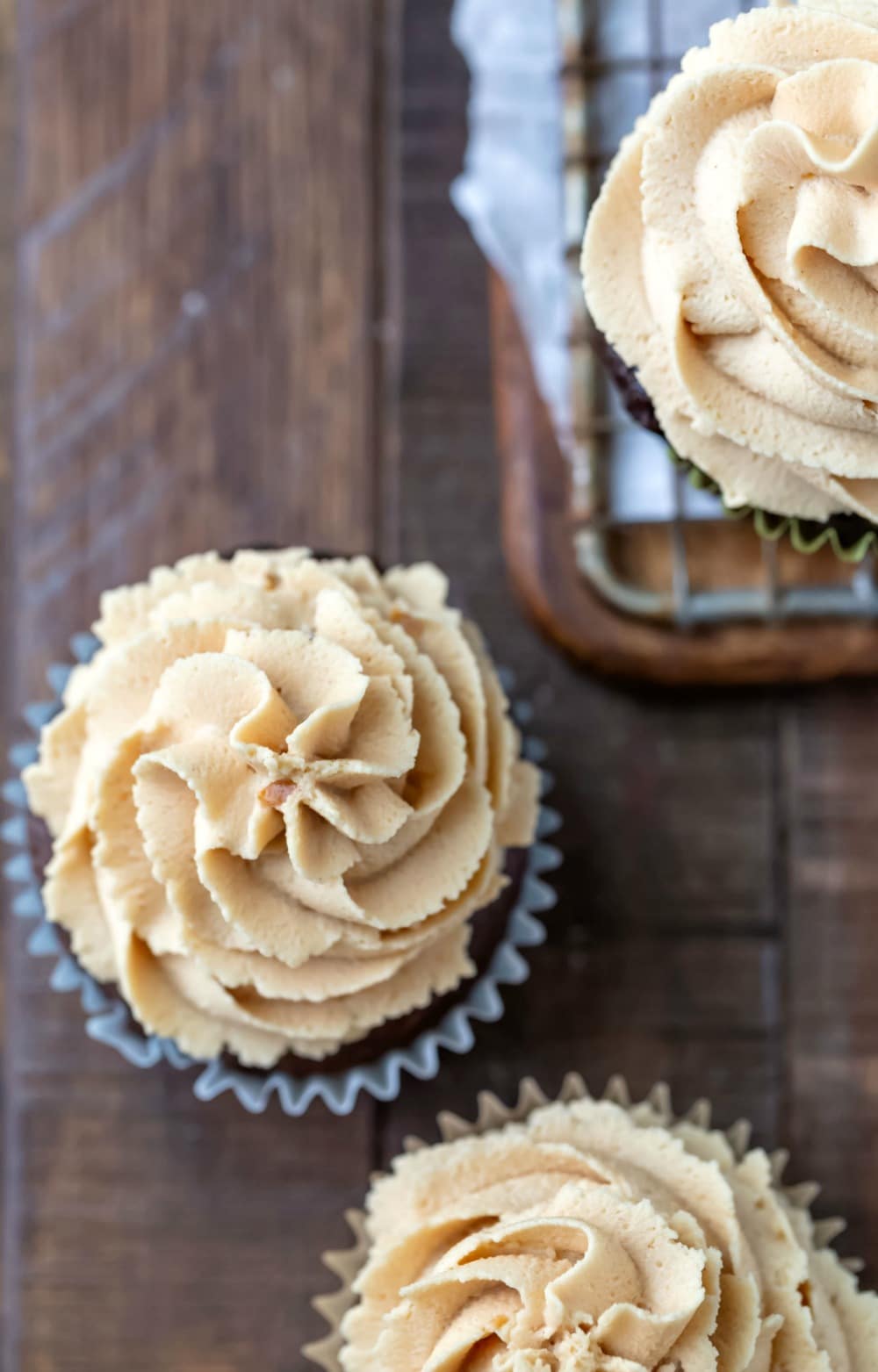 Peanut butter frosting on chocolate cupcake on a wooden background