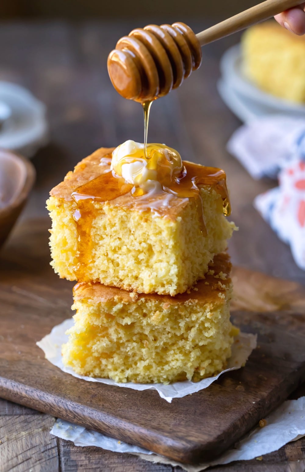 Stacked pieces of sweet cornbread with honey drizzled on top