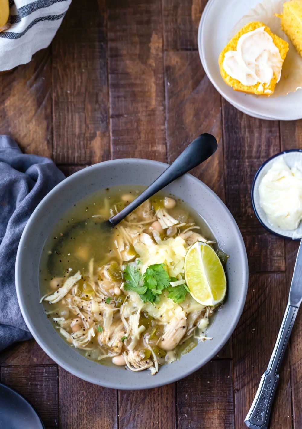 Instant pot white chicken chili in a blue bowl with a black spoon