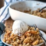 Apple crisp topped with a scoop of vanilla ice cream