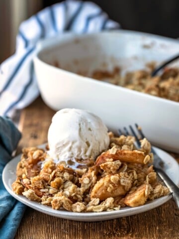 Apple crisp topped with a scoop of vanilla ice cream