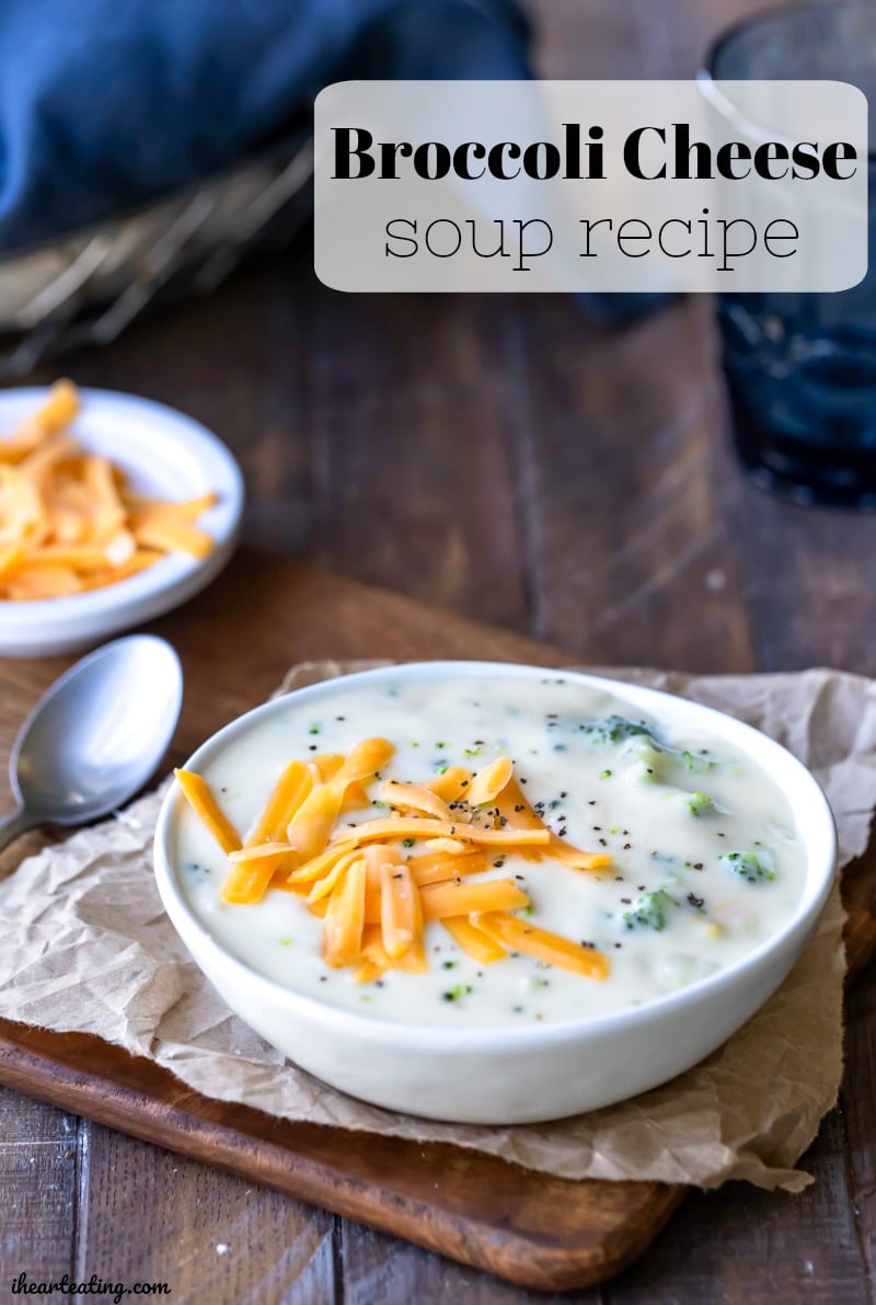 Broccoli Cheese soup in a white bowl topped with cheddar cheese and black pepper