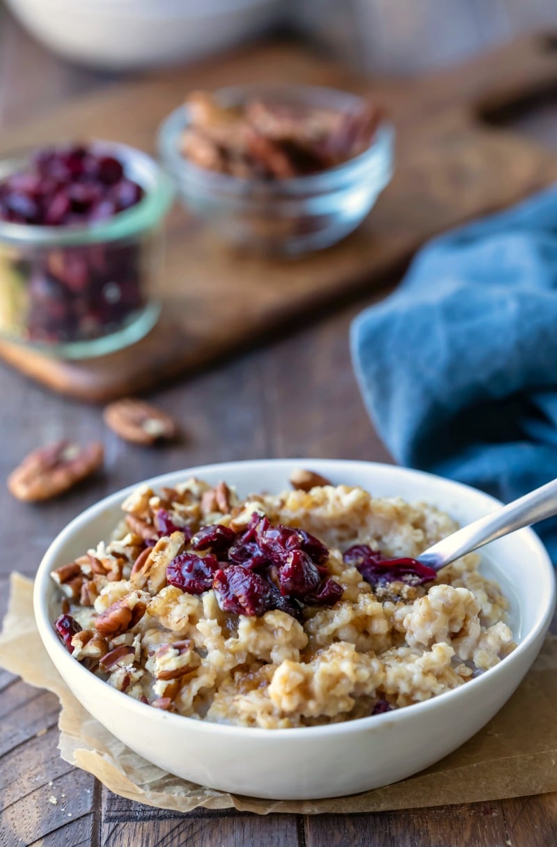 Instant pot steel cut oats in a white dish topped with dried cranberries