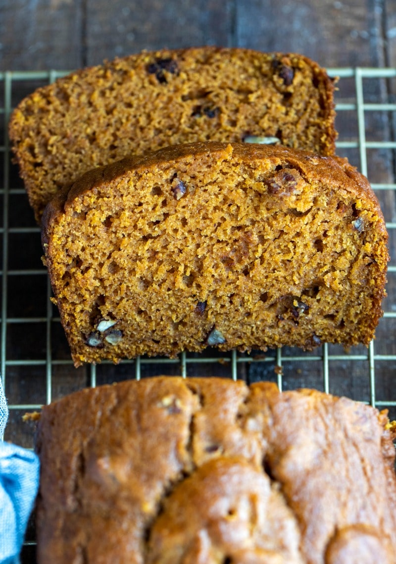 Two slices of pumpkin nut bread on a wire cooling rack