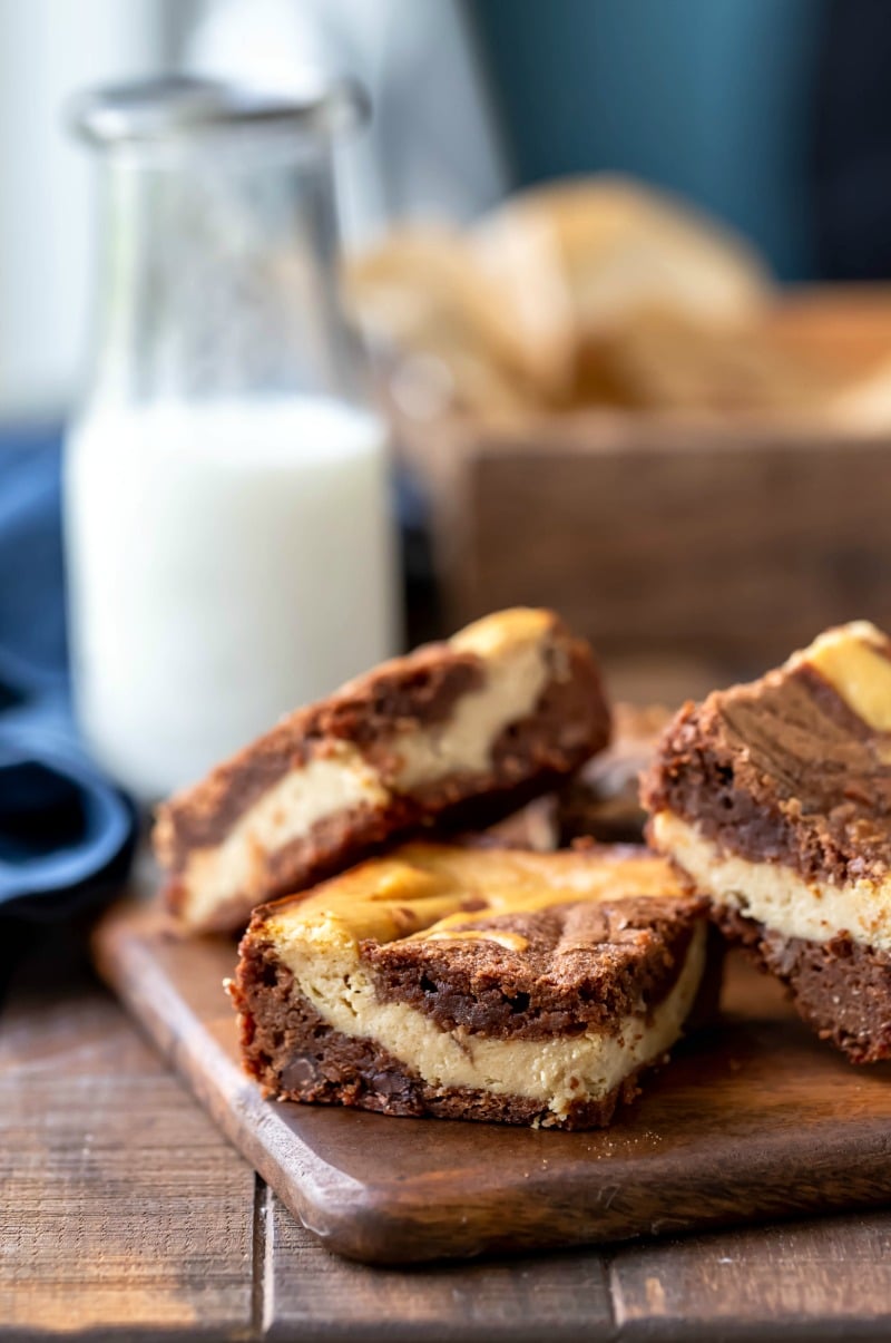 Three peanut butter brownies on a wooden cutting board