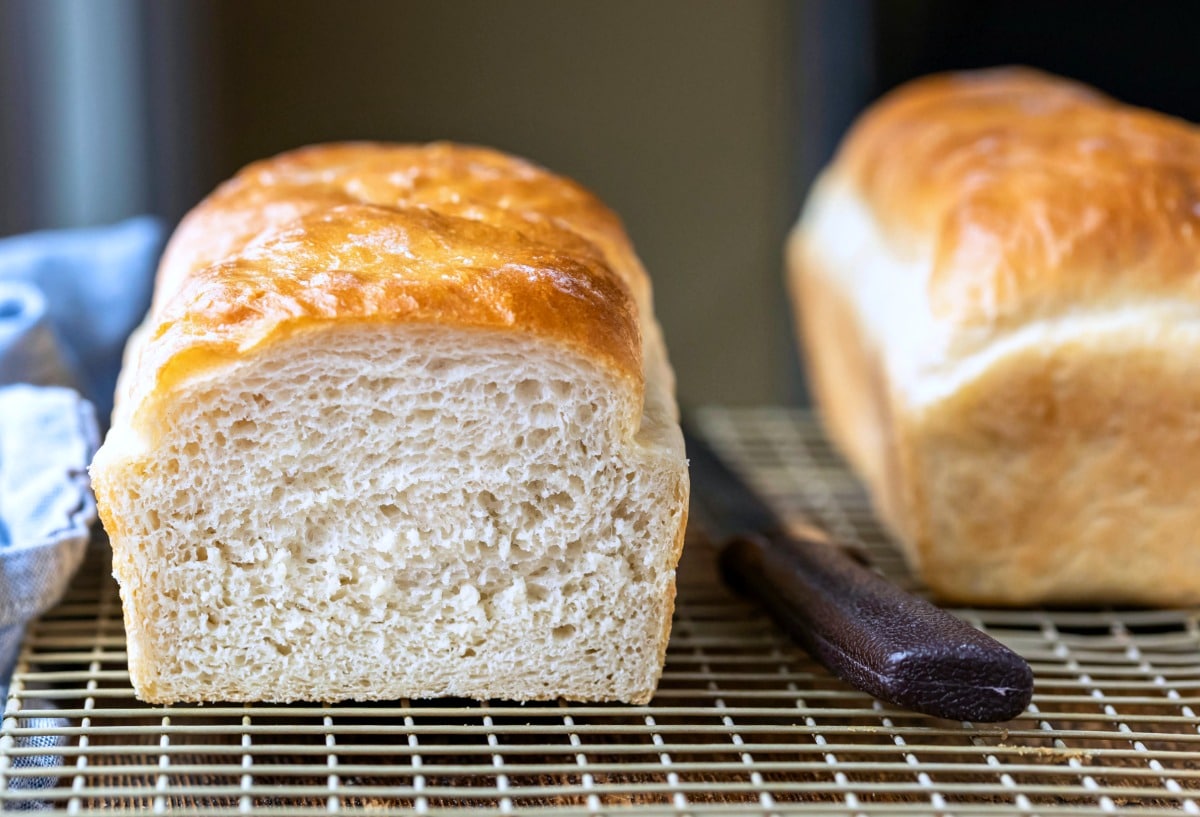 Homemade White Bread Recipe Loaf of white bread next to a bread knife