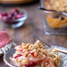 Cranberry apple crisp on a glass plate with a gold fork