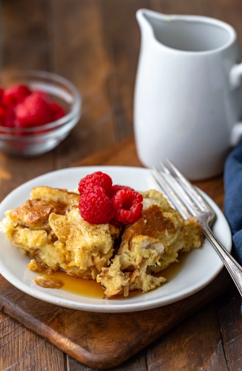 Crock pot French toast on a white plate topped with raspberries and syrup