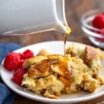 White carafe pouring maple syrup onto crock pot French toast