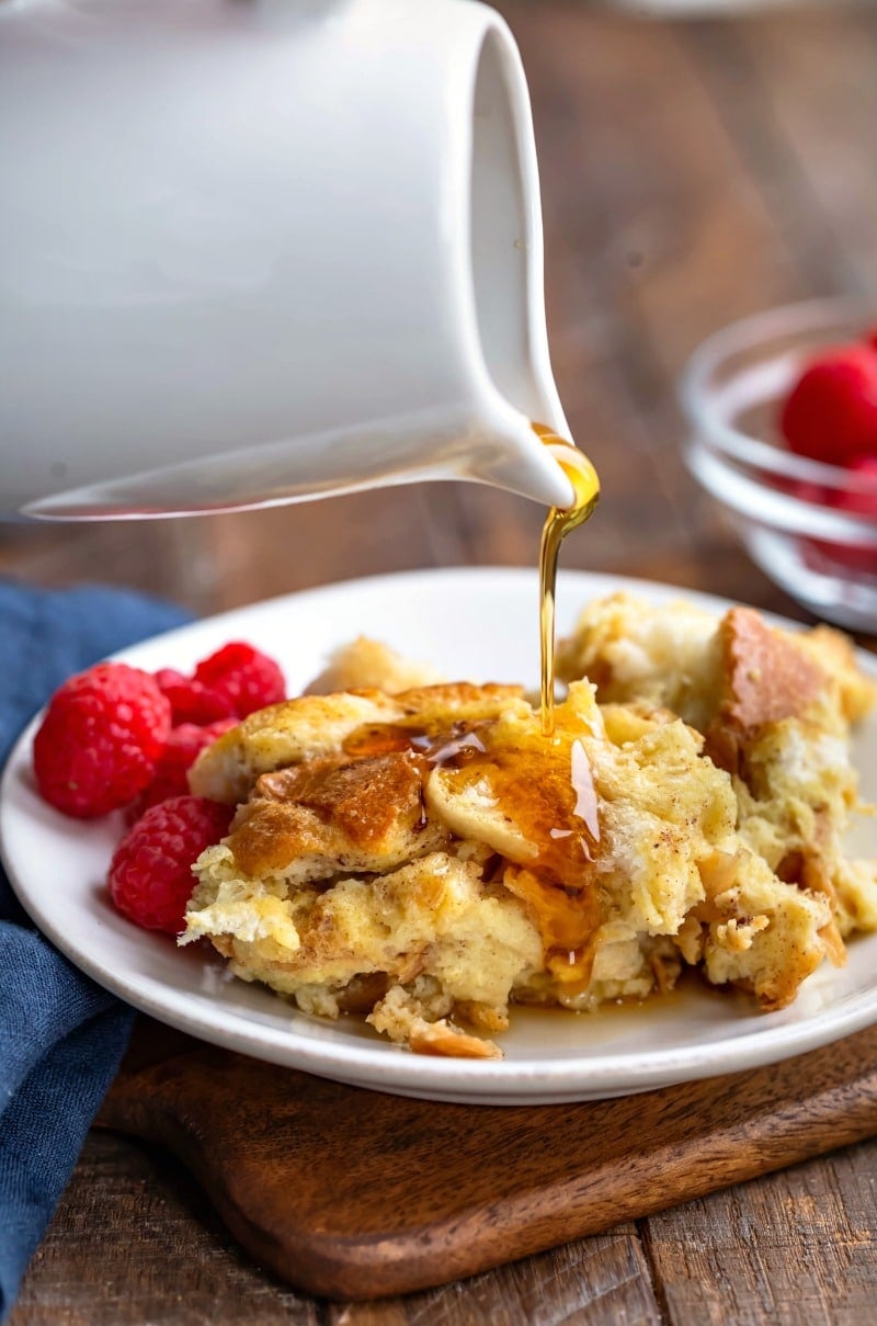 White carafe pouring maple syrup onto crock pot French toast