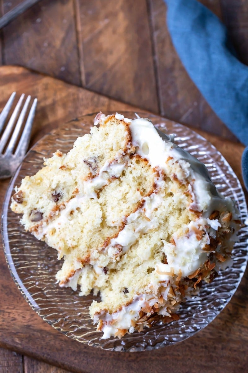 Slice of Italian cream cake on a wooden cutting board