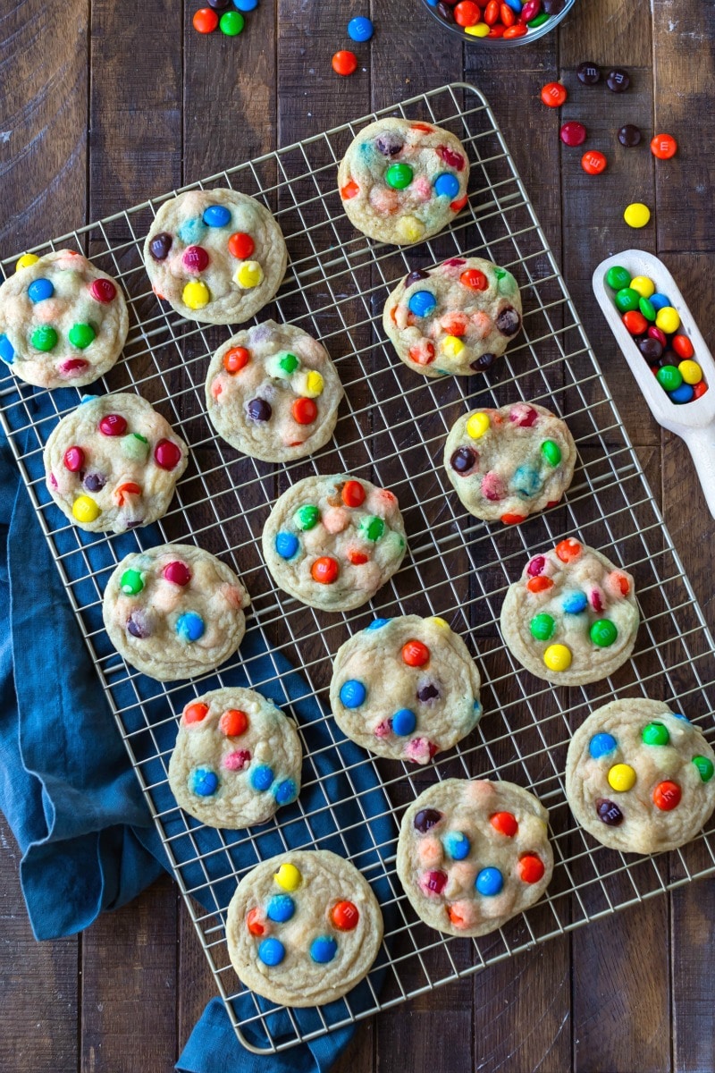 M&M cookies on a cooling rack next to a dish of M&Ms