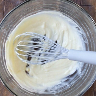 Melted butter and a gray whisk in a glass bowl
