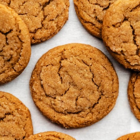 Molasses cookies on a sheet of white parchment paper.