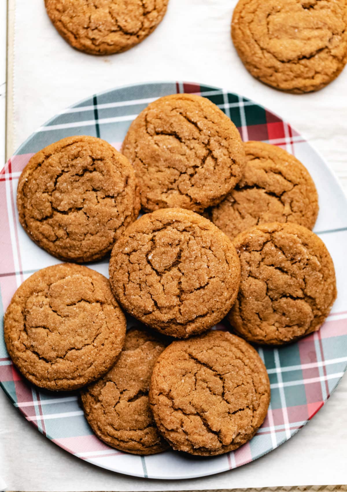 Molasses cookies on a red and green striped plate. 