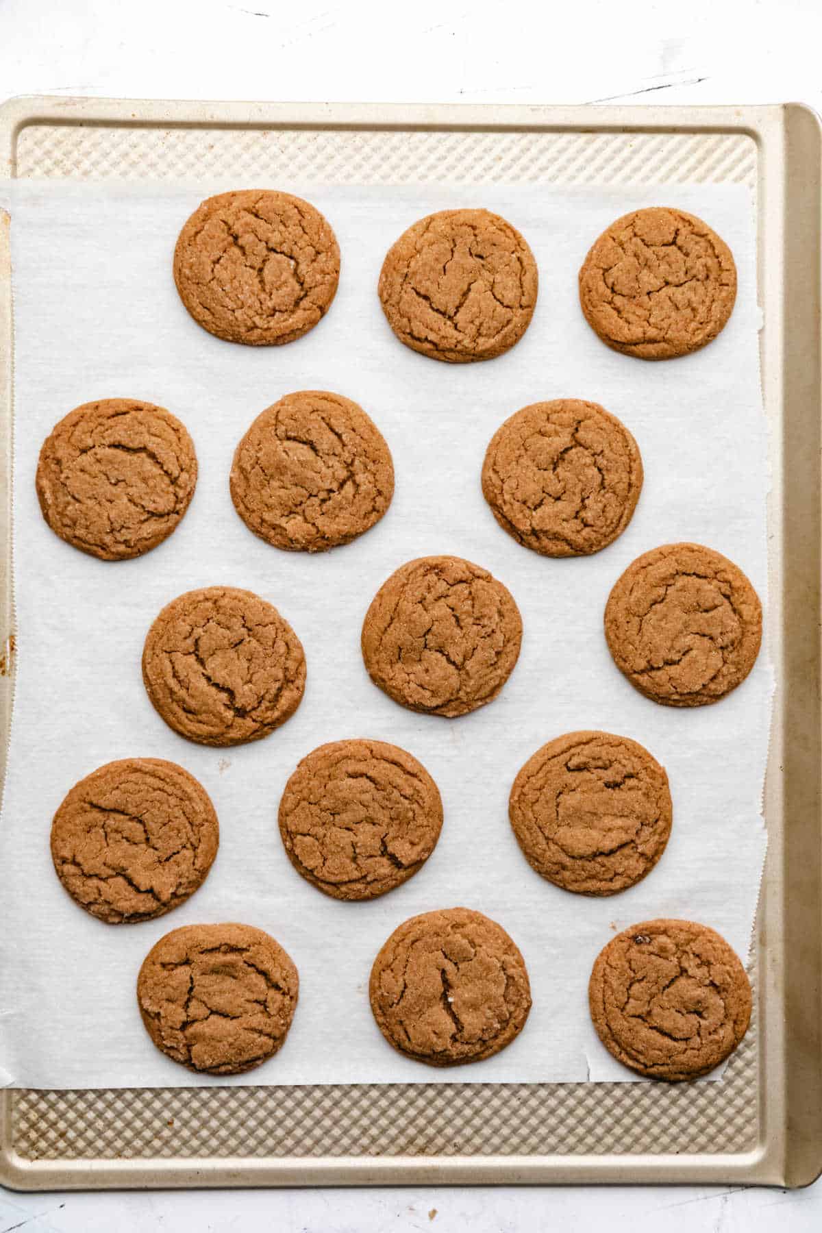 Baked molasses cookies on a baking sheet.