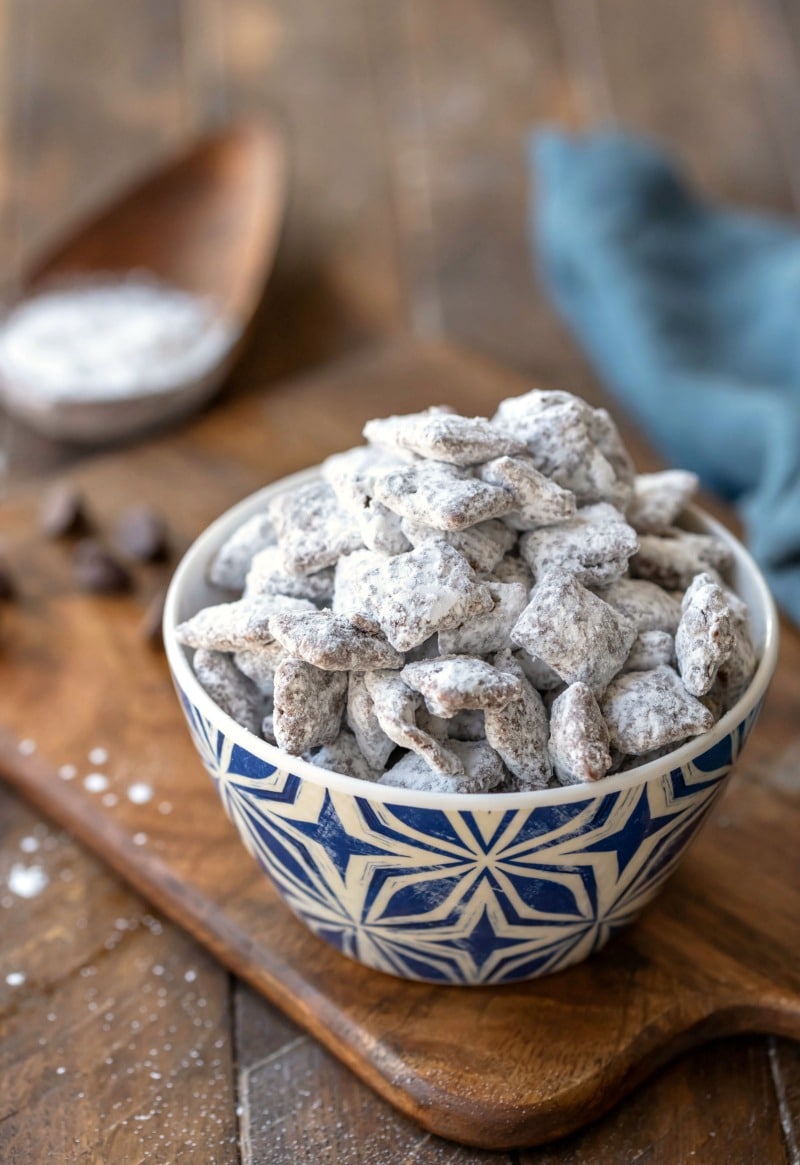 Bowl of puppy chow muddy buddies on a wooden cutting board