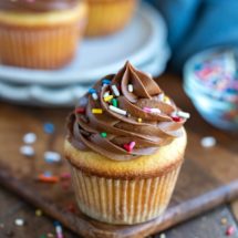 Yellow cupcake topped with chocolate frosting and sprinkles
