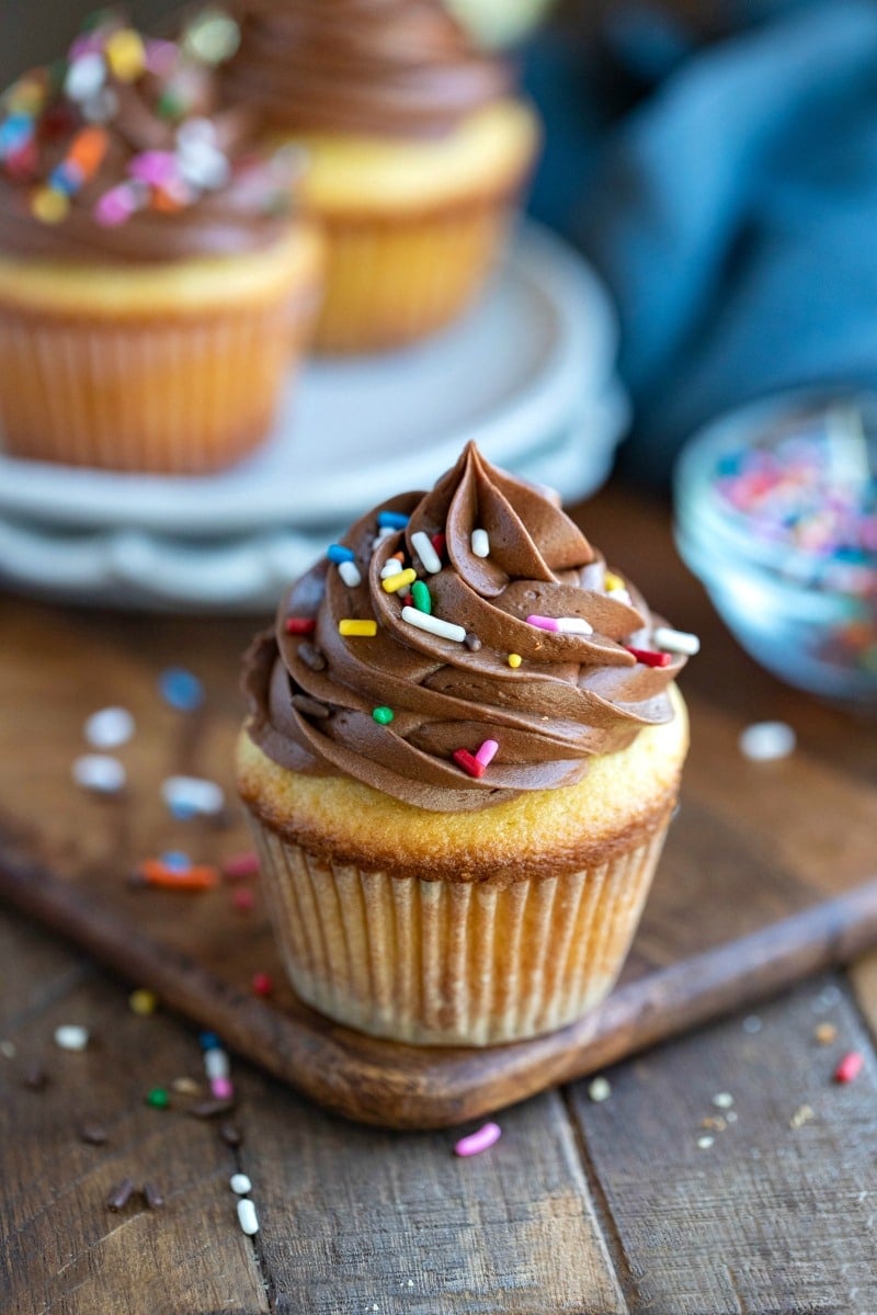 Yellow cupcake topped with chocolate frosting and sprinkles