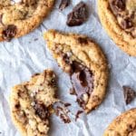 Broken whole wheat chocolate chunk cookie ona piece of parchment paper