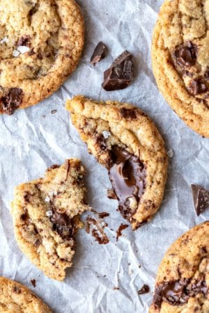 Broken whole wheat chocolate chunk cookie ona piece of parchment paper