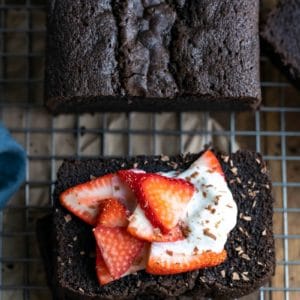 Slices of chocolate pound cake topped with strawberries and whipped cream