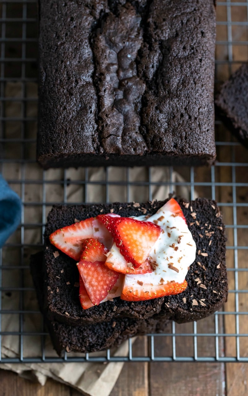 Slices of chocolate pound cake topped with strawberries and whipped cream