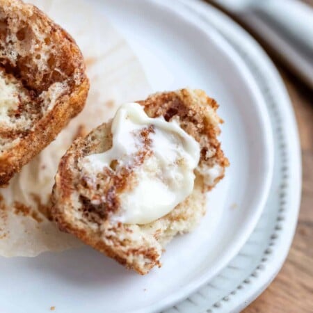 Buttered cinnamon muffin on a white plate.